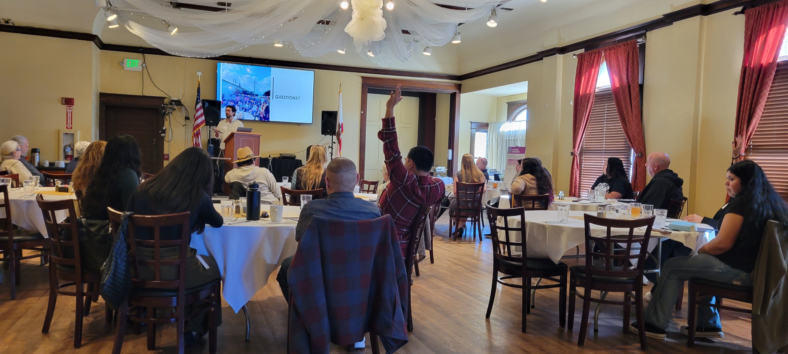 Photo of TAG #1 In-person meeting with attendee raising hand to ask question